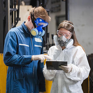 Workers wearing chemical protective mask and hazmat suit
